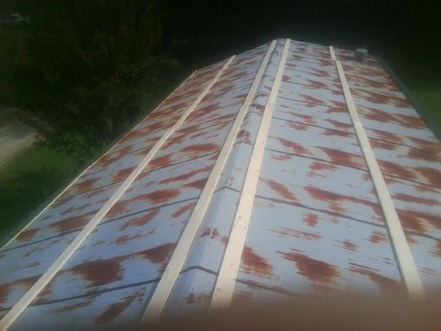 Rusted metal roof panels with new wood purlins before replacement — Storm Damage Roof Repair in Christmas by Roofing Brothers