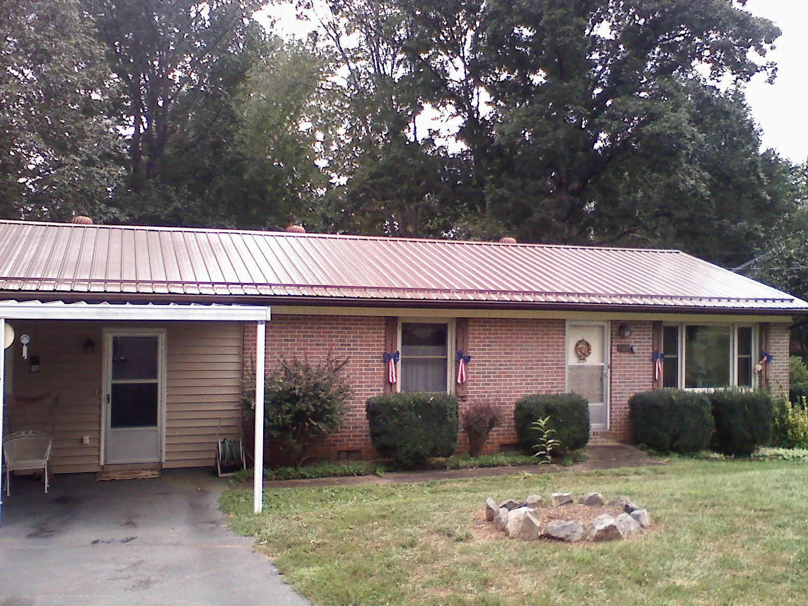 Bronze metal roof and carport on a brick ranch home — Roof Repair work by our crew in Christmas
